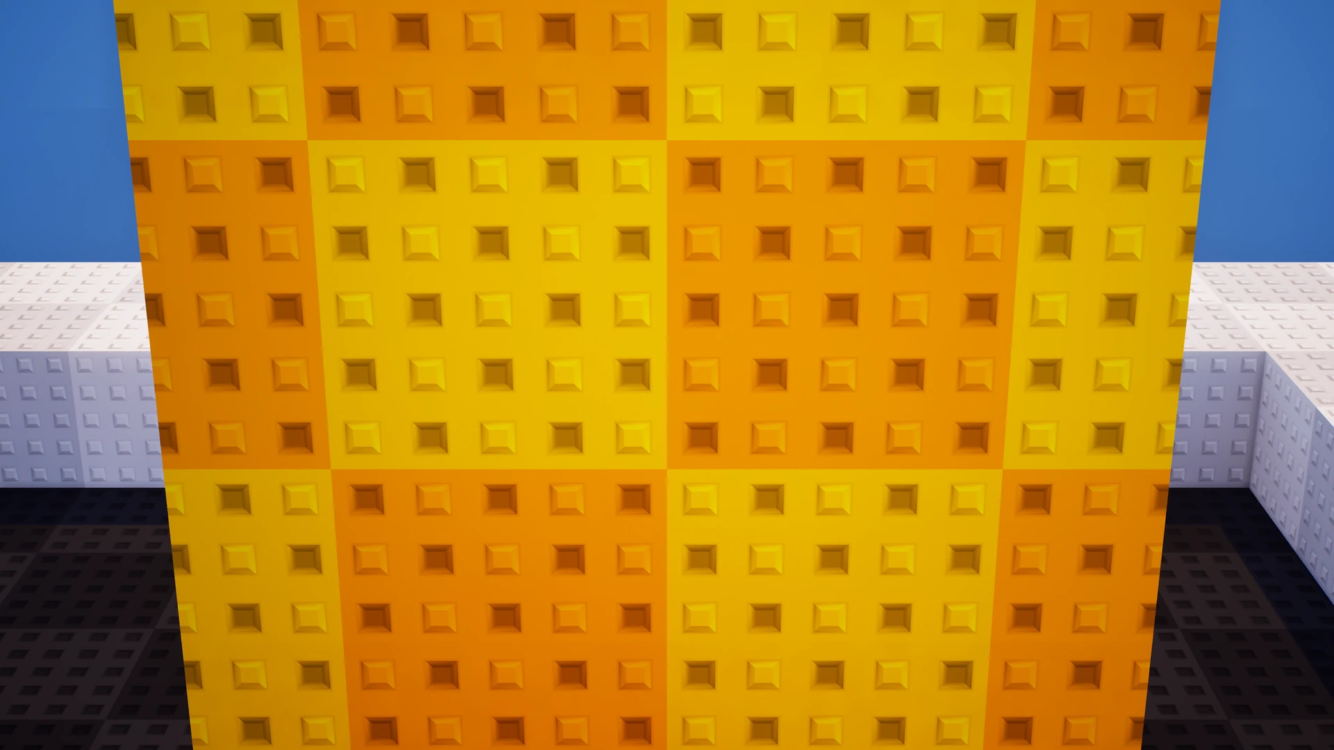 Close-up of a yellow and orange checkerboard wall alternating raised square studs and recessed square inlets.
